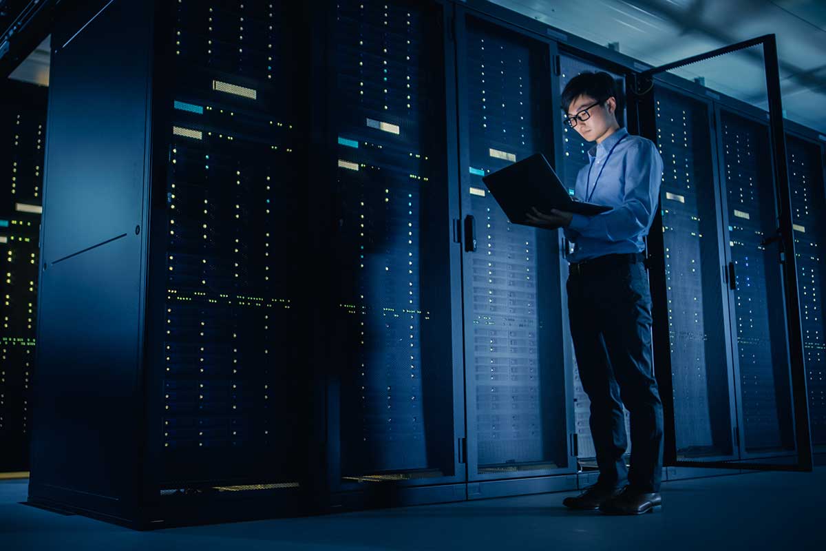 person holding laptop inside data center