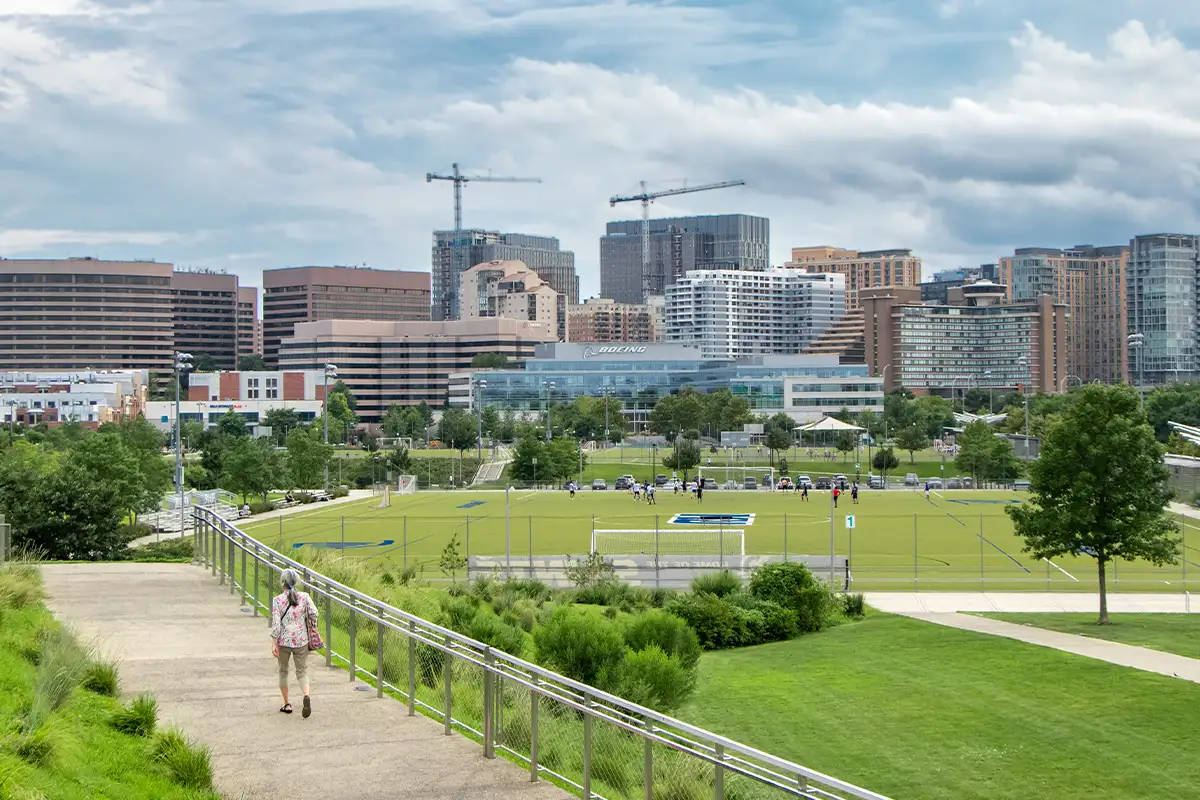 a woman walks on a path with Arlington in the background