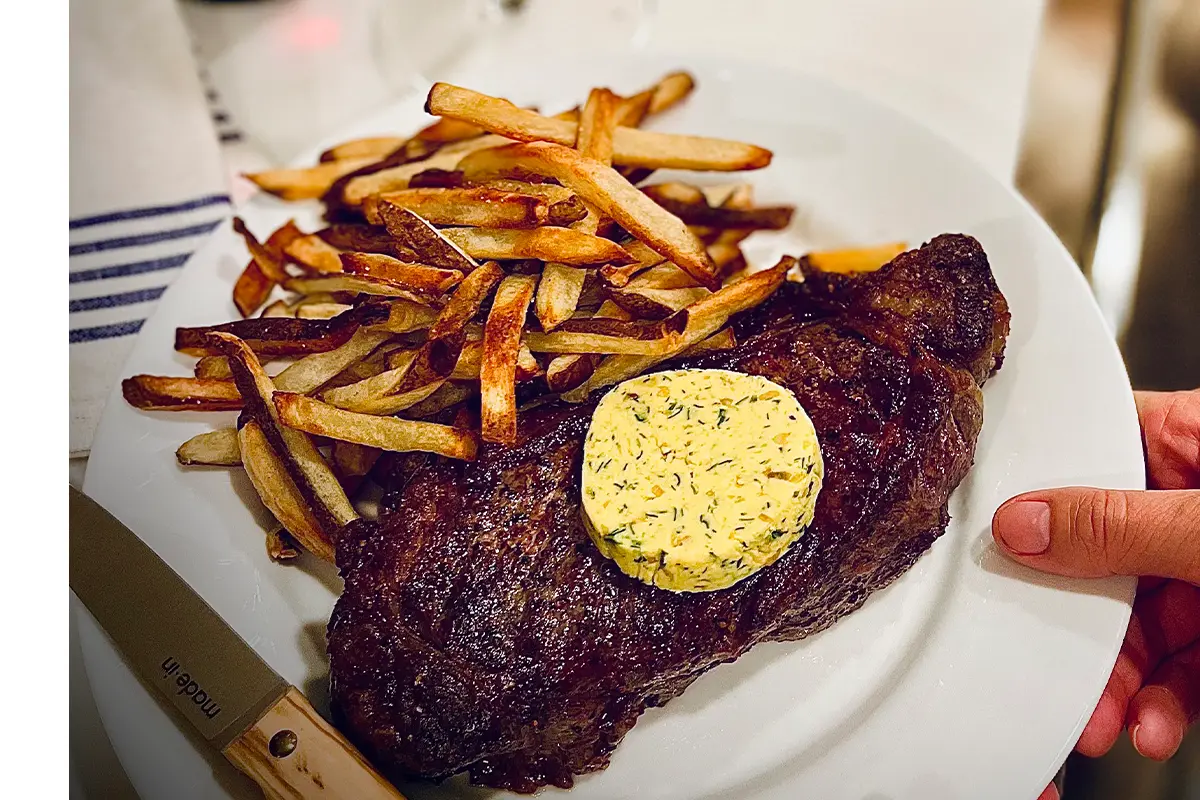 a plate with steak and fires from Brasserie Royale