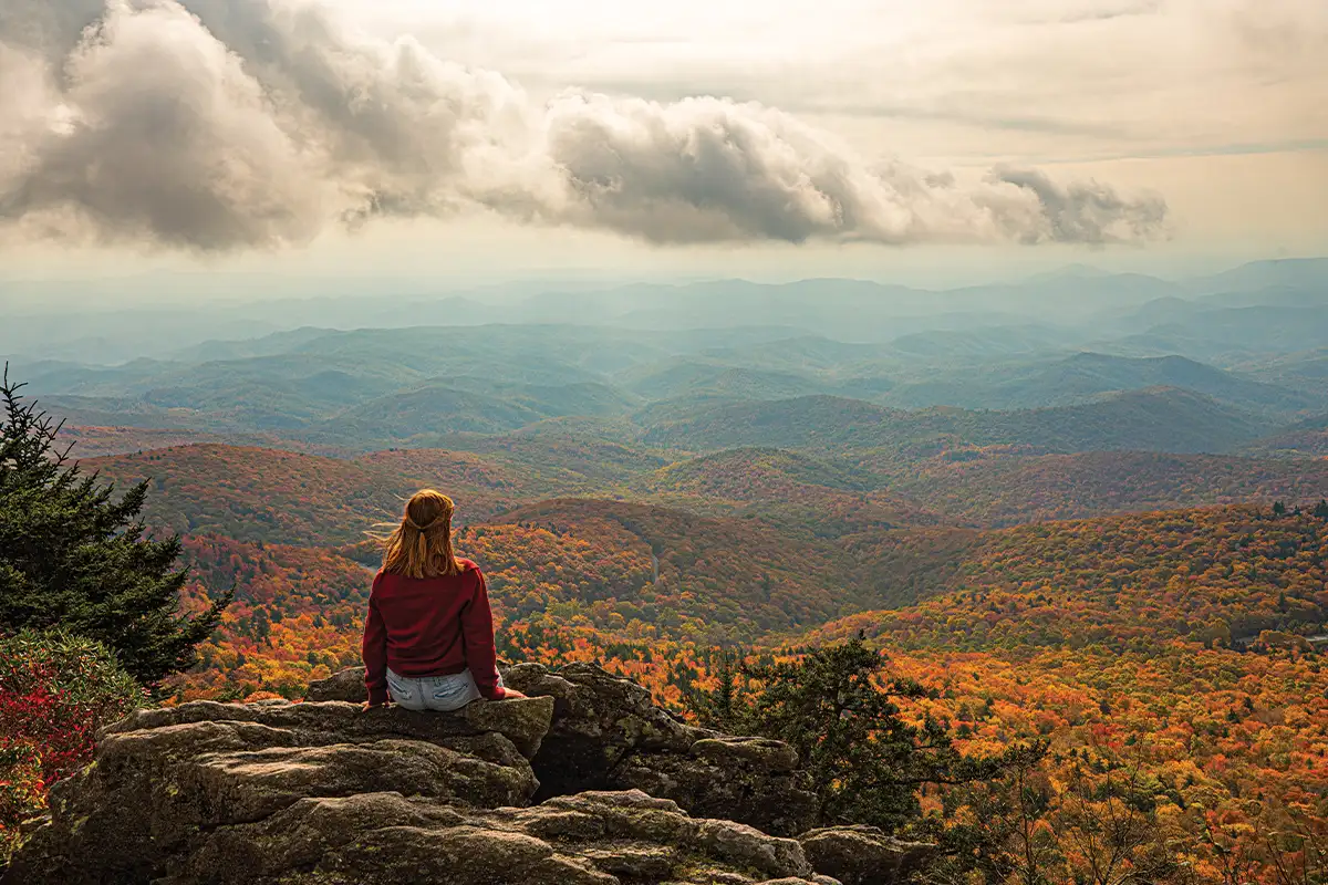 Woman sitting on scenic overlook in Asheville, NC