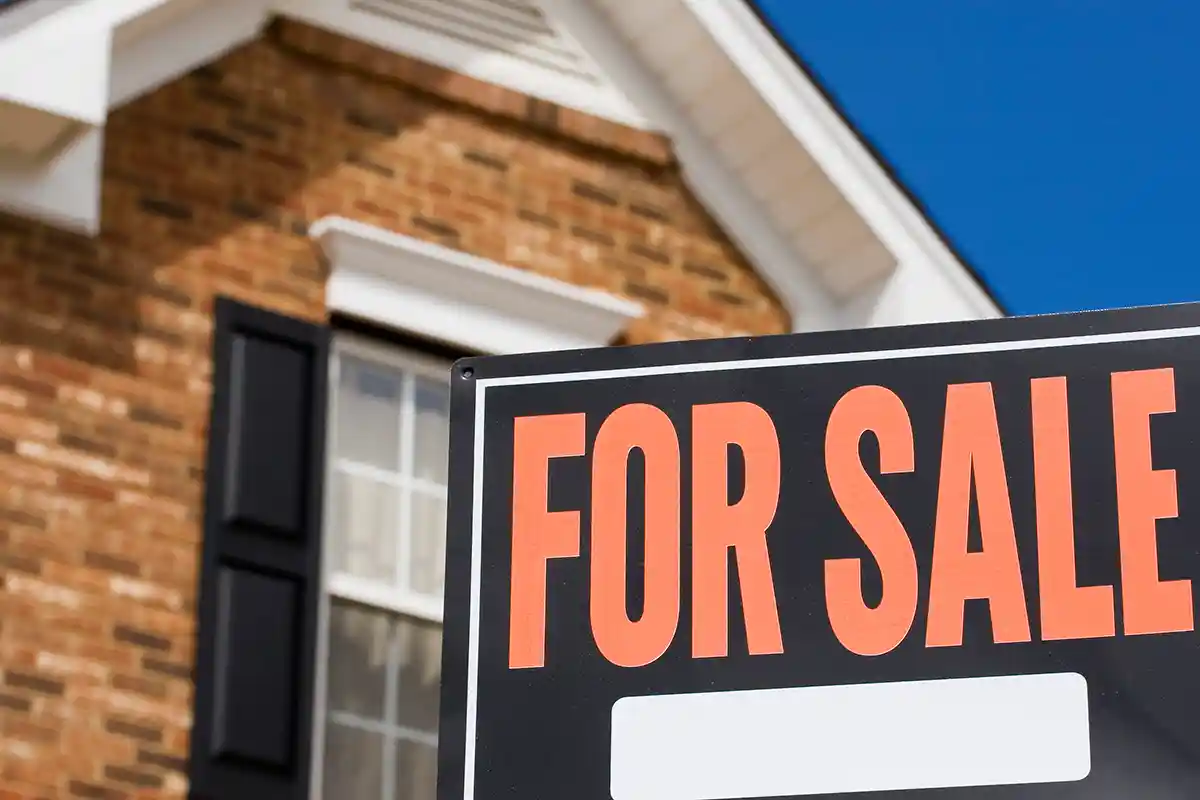 roof view of a home with a for sale sign in front