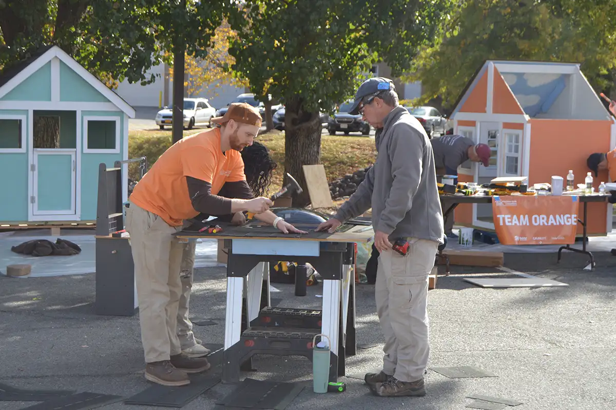 Grunley COnstruction volunteers build a skylight in a playhouse roof.