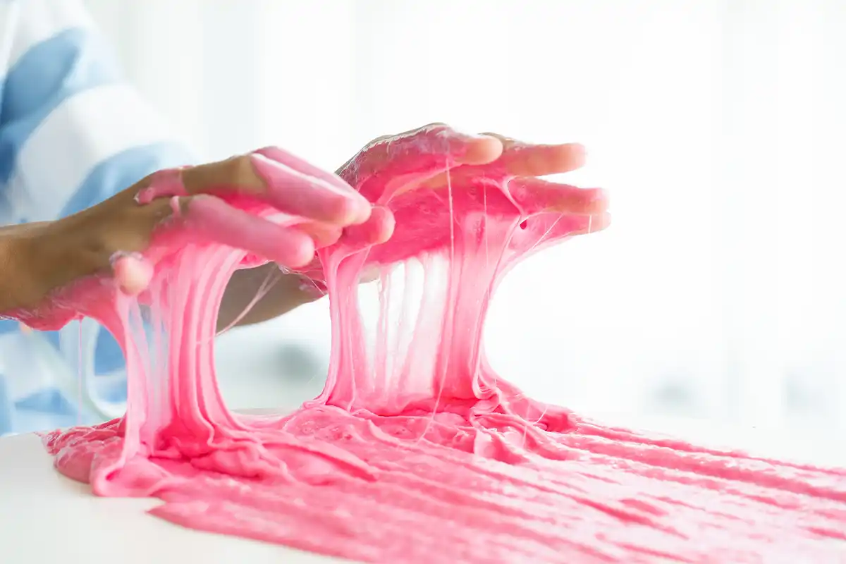 person with pink slime on hands