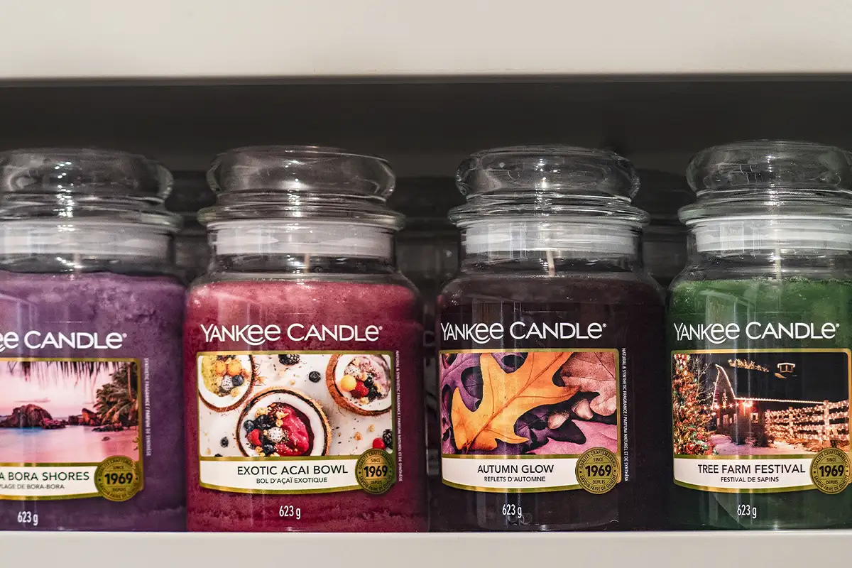 a row of four Yankee Candle on a shelf